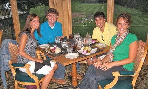 Four people sitting around a table eating.