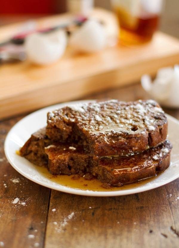 Gingerbread loaves sliced and grilled into Gingerbread French Toast on a plate with syrup.