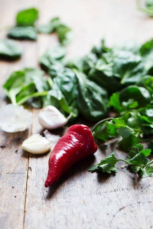 Garlic and herbs on a wooden surface.